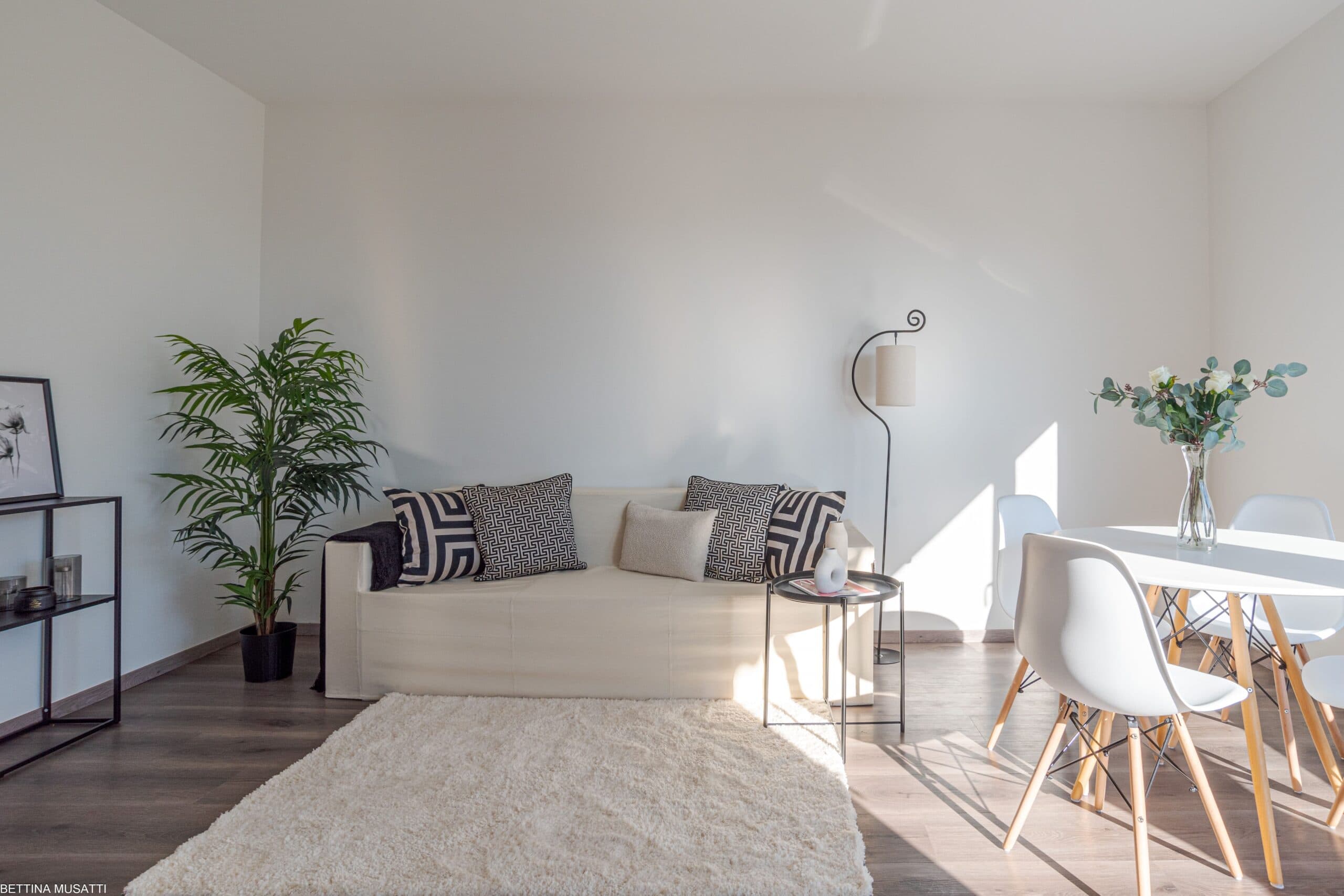 Living room staged with a sofa and dining area in an apartment in central Lugano